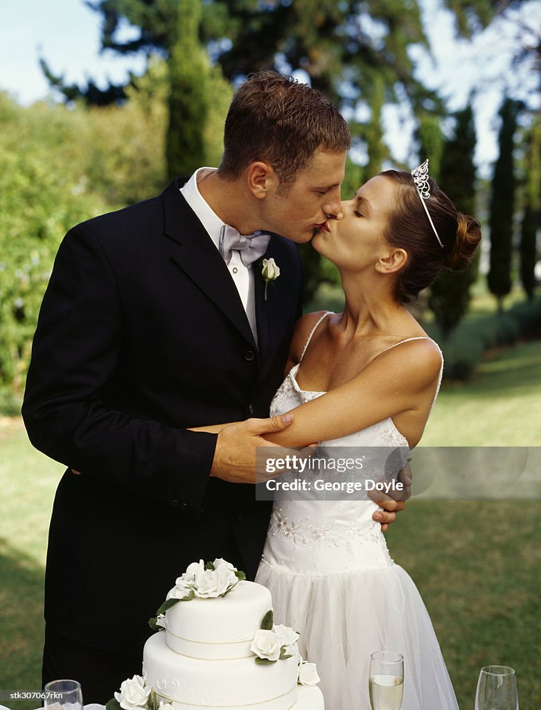 Side profile of a newlywed couple kissing