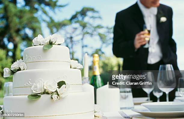 mid section view of a man holding a glass of champagne - champagner gläser mit flasche unscharfer hintergrund stock-fotos und bilder
