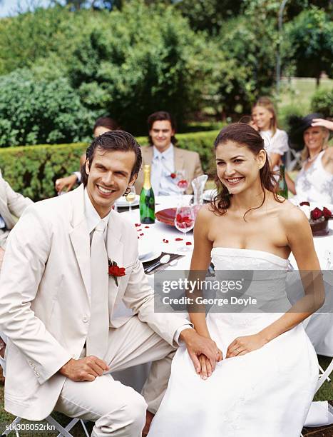 newlywed couple sitting together and holding hands - rosaceae stock pictures, royalty-free photos & images