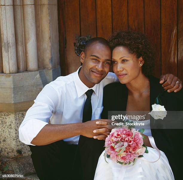 newlywed couple sitting outside a church - rosaceae stock pictures, royalty-free photos & images