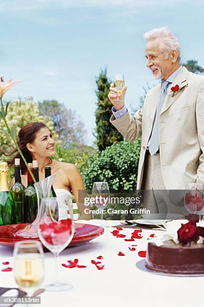 bride with a mature man raising a toast - rosaceae stock pictures, royalty-free photos & images