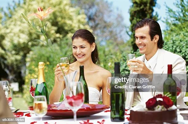 newlywed couple raising a toast at their wedding reception - rosaceae stock pictures, royalty-free photos & images