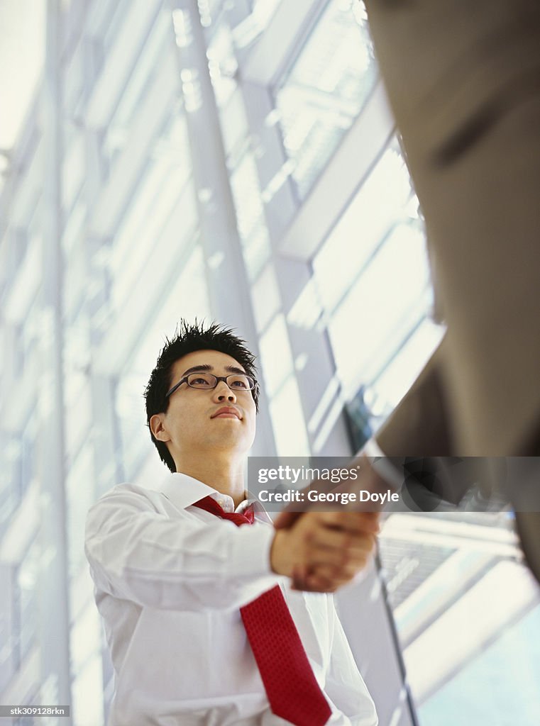 Low angle view of two businessmen shaking hands
