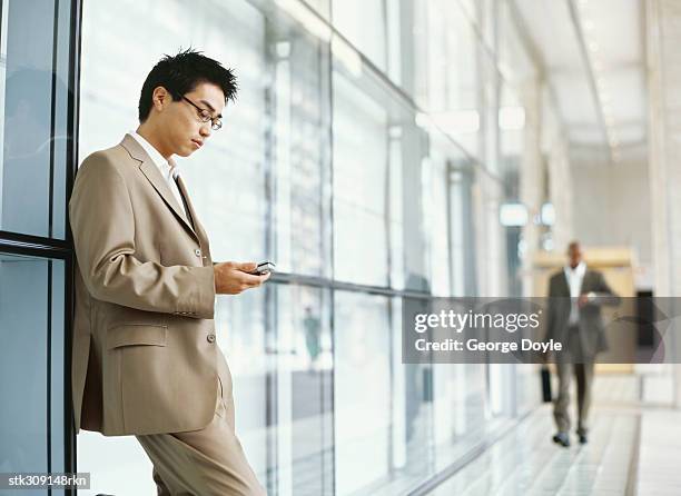 side profile of a businessman using a mobile phone - brown suit stock pictures, royalty-free photos & images