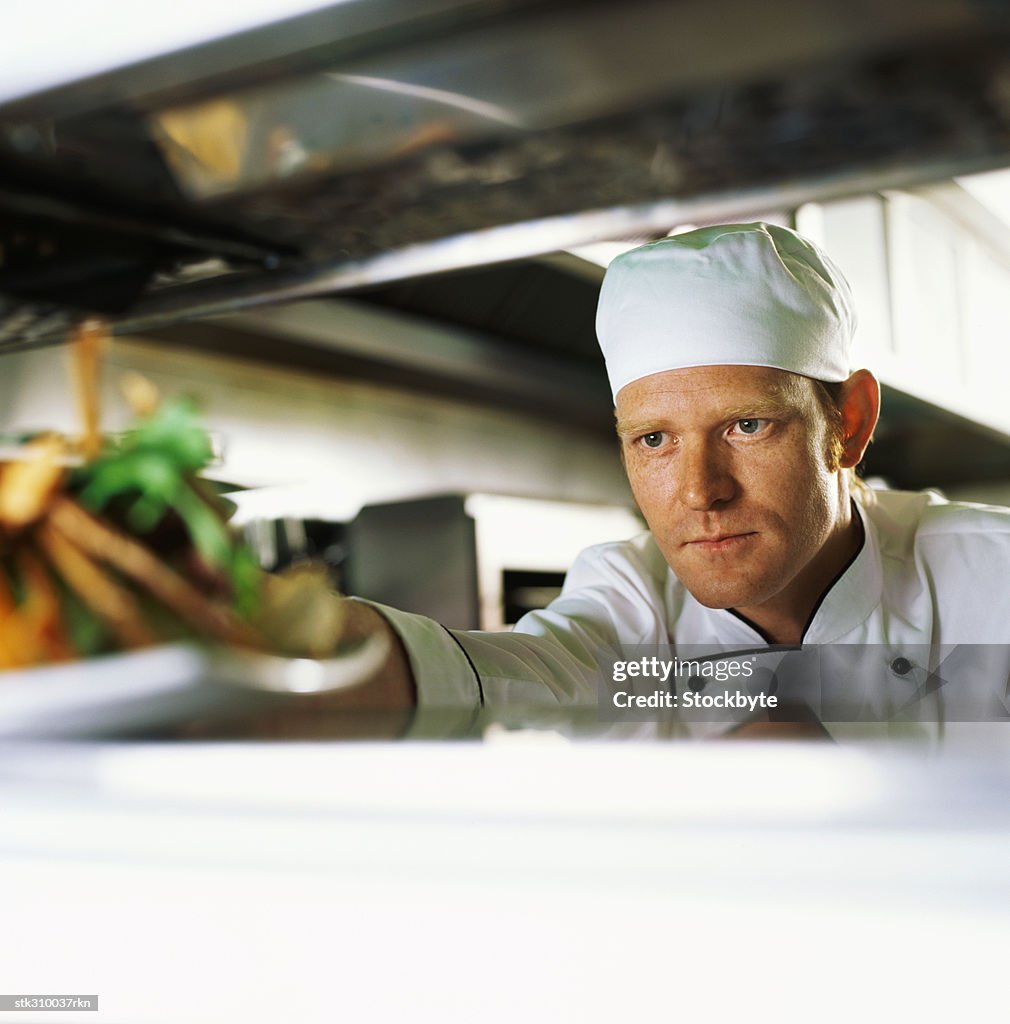 Chef taking food from a shelf in the kitchen