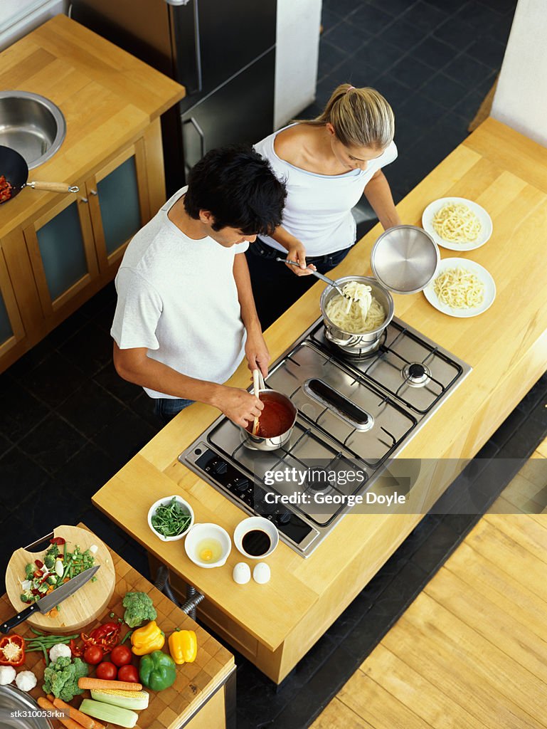 High angle view of a young couple cooking food in the kitchen