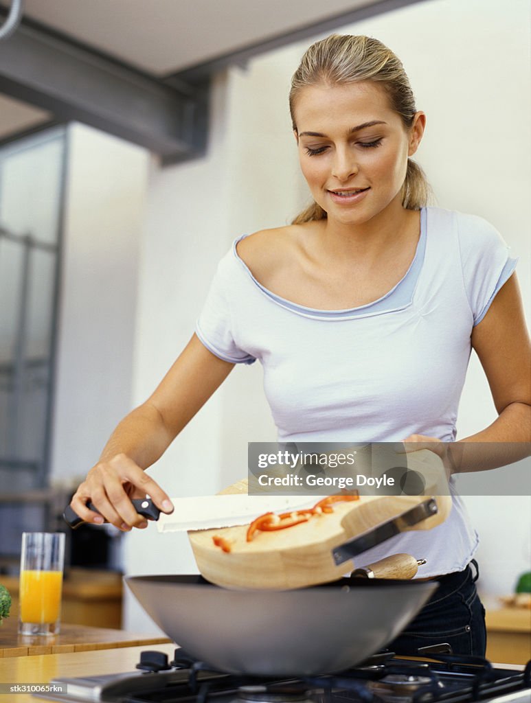 Young woman cooking food in the kitchen