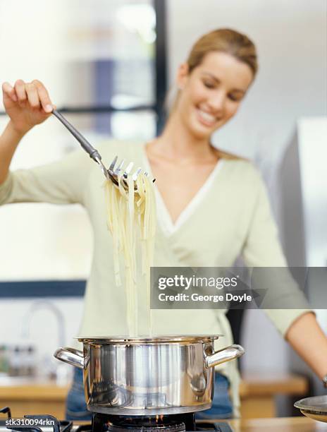 young woman cooking food in the kitchen - lid stock pictures, royalty-free photos & images