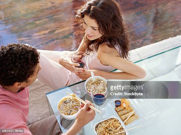 high angle view of a young couple sitting on a dining table and eating their food - dark haired man gray shirt with wine stock pictures, royalty-free photos & images