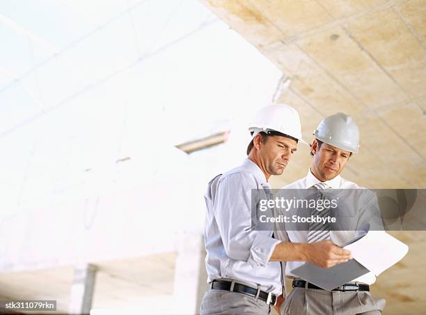 architects holding a clipboard at a construction site - inside the link real estate investment trust properties ahead of interim results stockfoto's en -beelden