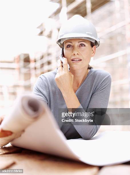 female architect talking on a mobile phone at a construction site - inside the link real estate investment trust properties ahead of interim results stockfoto's en -beelden