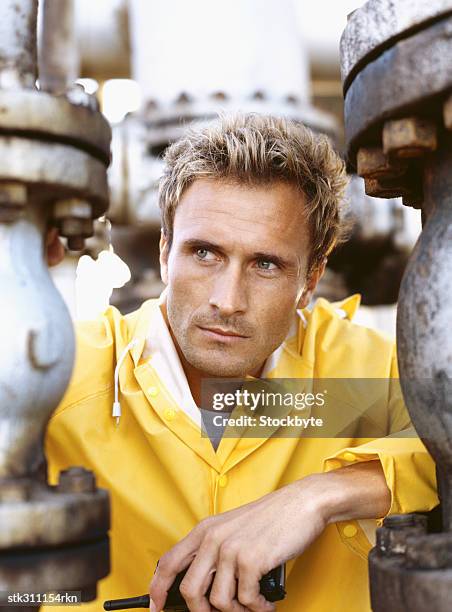 technician holding a walkie-talkie, standing in an oil refinery - transceiver stock pictures, royalty-free photos & images