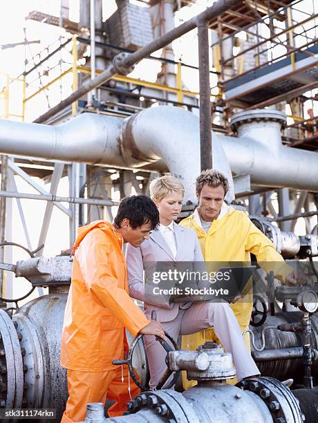 female engineer standing with two mechanics and using a laptop - swedish royals attend the royal swedish academy of engineering sciences formal gathering stockfoto's en -beelden