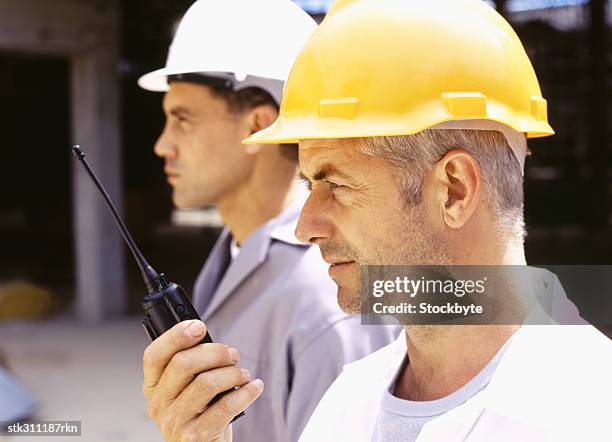 construction worker and an architect holding a walkie-talkie at a construction site - transceiver stock pictures, royalty-free photos & images