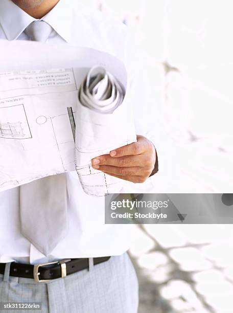 mid section view of an architect holding blueprints at a construction site - swedish royals attend the royal swedish academy of engineering sciences formal gathering stockfoto's en -beelden