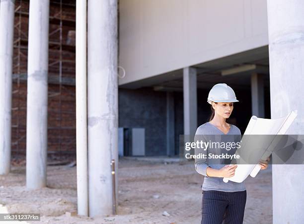 female architect holding a blueprint - design occupation stock pictures, royalty-free photos & images