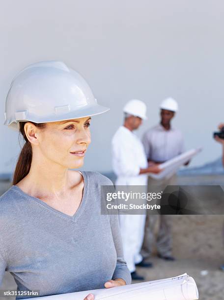 female architect holding a blueprint - trabalho de design imagens e fotografias de stock