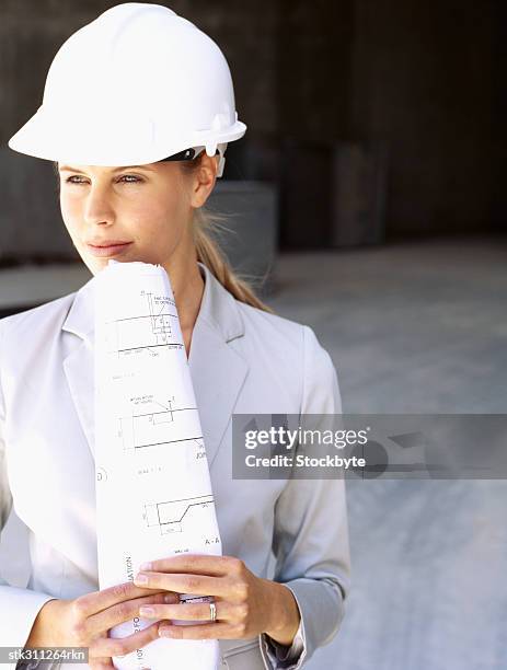 close-up of a female architect holding a blueprint - métier du design photos et images de collection