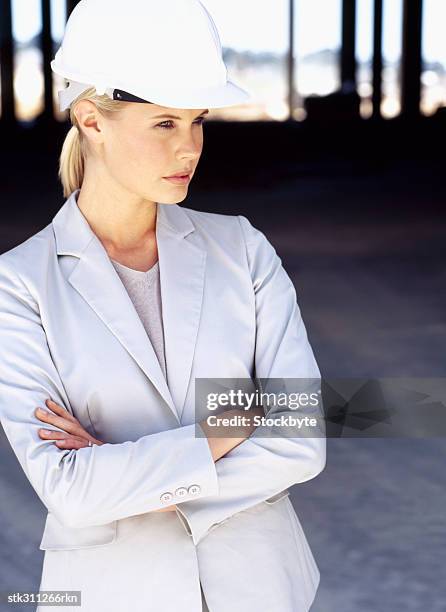 close-up of a female architect wearing a hardhat at a construction site - ontwerp beroep stockfoto's en -beelden