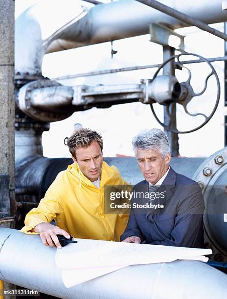 male engineer and a mechanic discussing a blueprint - transceiver stock pictures, royalty-free photos & images