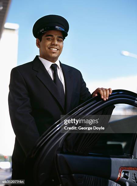 chauffeur opening the door of a car - the opening day of goodwood races march 24 2004 stockfoto's en -beelden