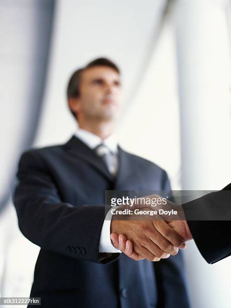 two businessmen shaking hands in an office - suit and tie stock pictures, royalty-free photos & images