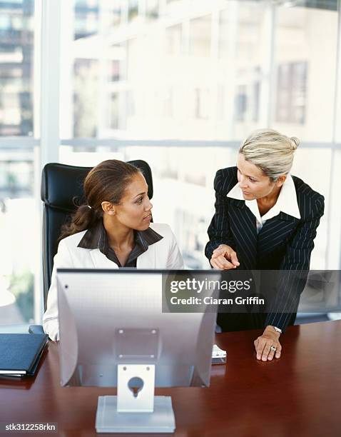 two businesswomen discussing in front of a computer - secretary of the interior ken salazar hosts reception to recognize the national park service and the american latino initiative stockfoto's en -beelden