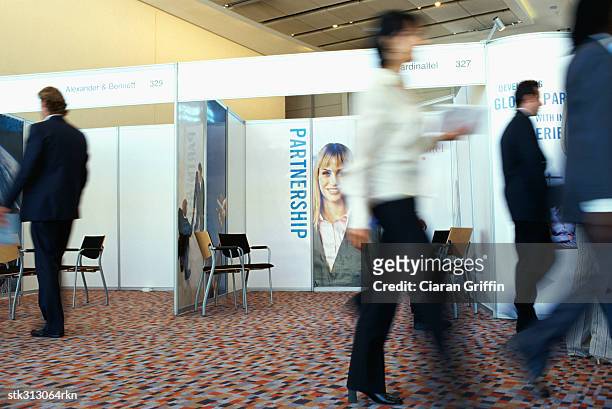 business executives walking at an exhibition - tradeshow stock pictures, royalty-free photos & images