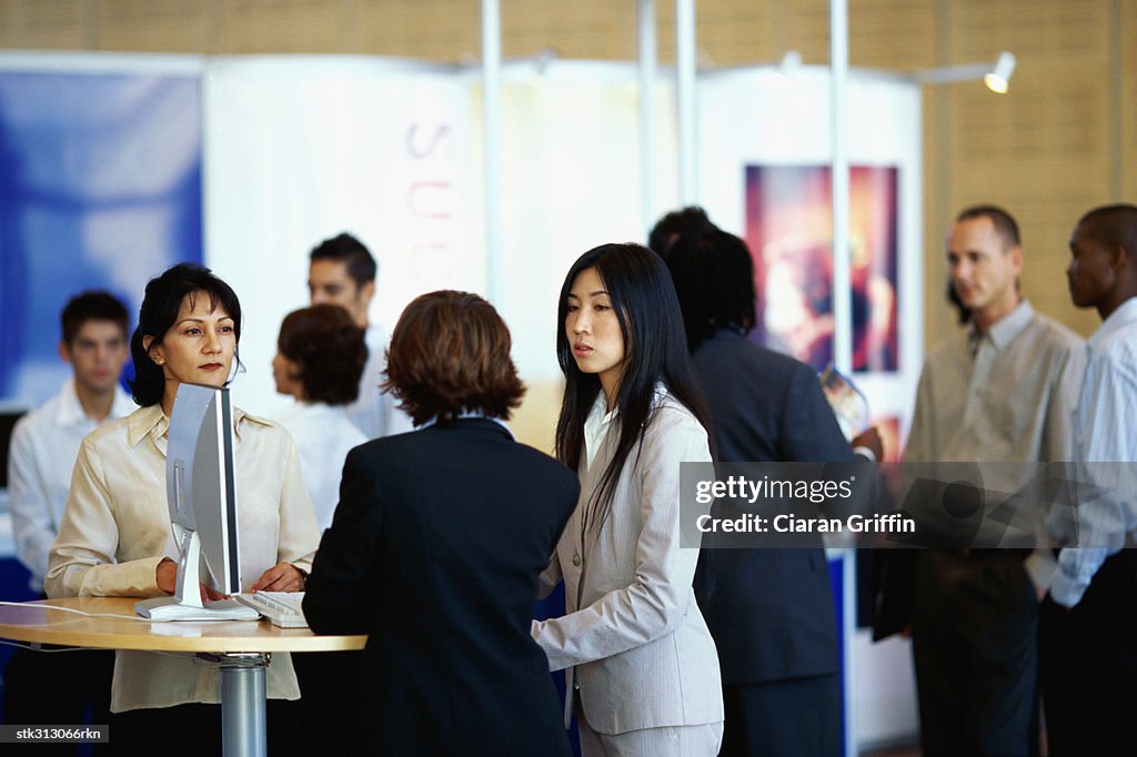 Three businesswomen discussing at an exhibition