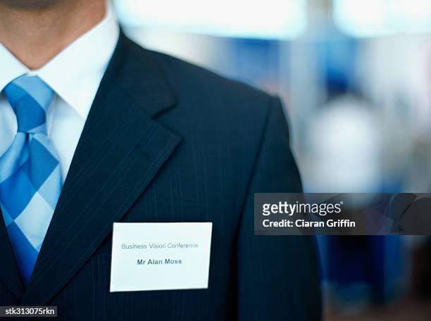 mid section view of a businessman wearing an id card on his suit - shirt tag stock pictures, royalty-free photos & images
