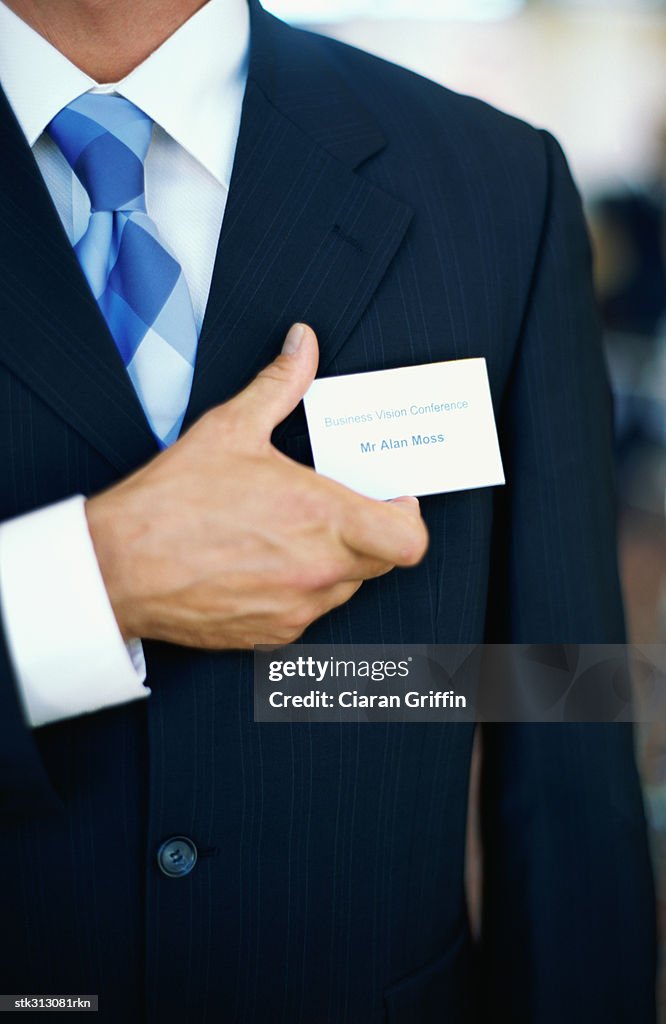 Mid section view of a businessman adjusting his id card