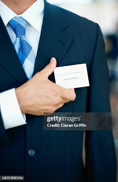 mid section view of a businessman adjusting his id card - shirt tag stock pictures, royalty-free photos & images