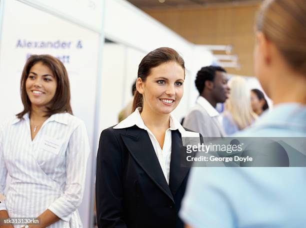 three businesswomen at an exhibition - tradeshow stock pictures, royalty-free photos & images