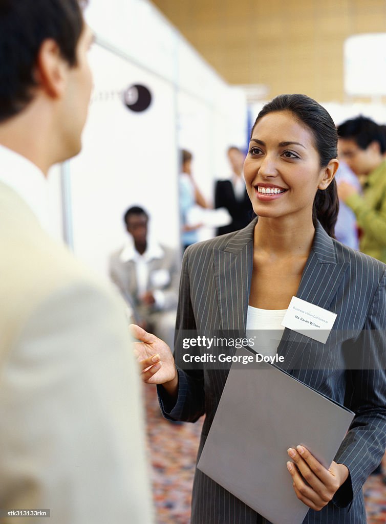 Businesswoman and a businessman discussing at an exhibition