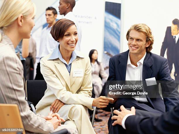 business executives discussing at an exhibition - hand on knee stock pictures, royalty-free photos & images