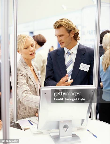 businessman and a businesswoman discussing at an exhibition - king juan carlos and queen sofia attends 25th anniversary tribute of seville universal exhibition stockfoto's en -beelden