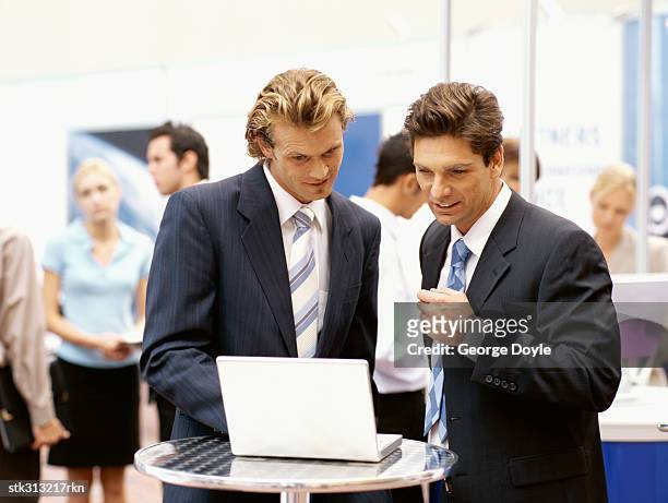 two businessmen using a laptop at an exhibition - king juan carlos and queen sofia attends 25th anniversary tribute of seville universal exhibition stockfoto's en -beelden