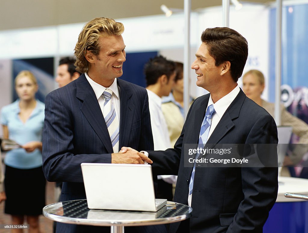 Two businessmen shaking hands at an exhibition