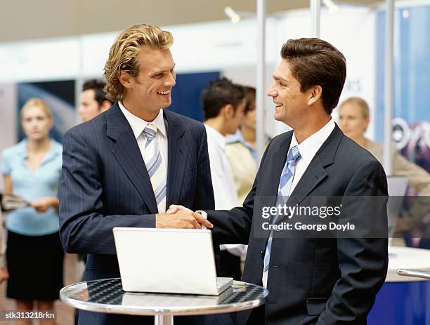 two businessmen shaking hands at an exhibition - king juan carlos and queen sofia attends 25th anniversary tribute of seville universal exhibition stockfoto's en -beelden