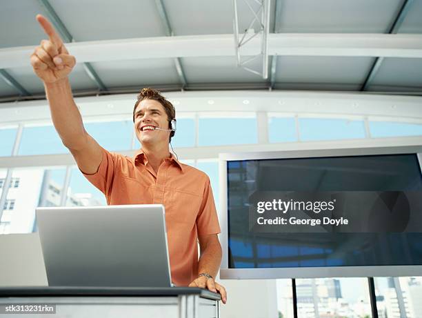 low angle view of a businessman pointing forward at a seminar - working on laptop in train top view imagens e fotografias de stock