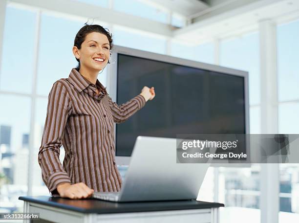 businesswoman pointing to a projection screen at a seminar - presentation of the book scenes de crime au louvre written by christos markogiannakis in paris stockfoto's en -beelden