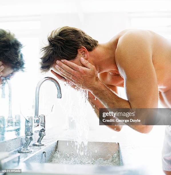 side profile of a man washing his face in the basin - basin ストックフォトと画像