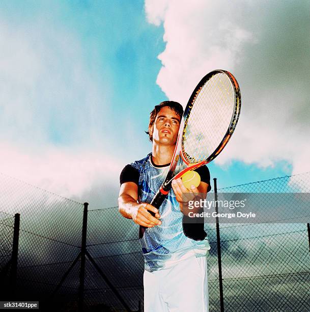 low angle close-up of a man about to serve in a game of tennis - tennis raquet close up photos et images de collection