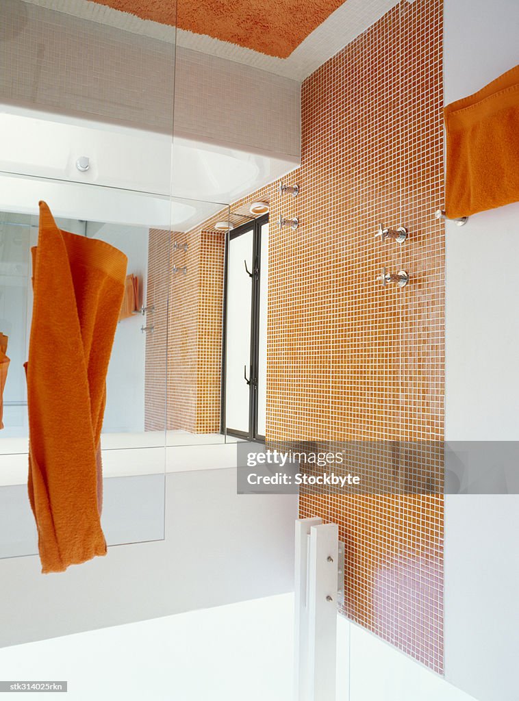 Orange towels hanging in a bathroom