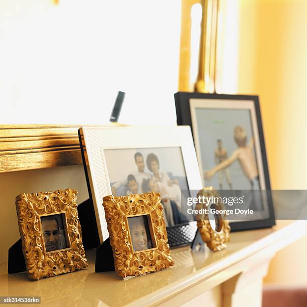 picture frames on a mantelpiece - mantelpiece stock pictures, royalty-free photos & images