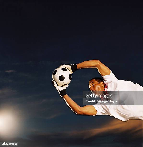 shot of a soccer goalkeeper making a save - making a save sports stock-fotos und bilder