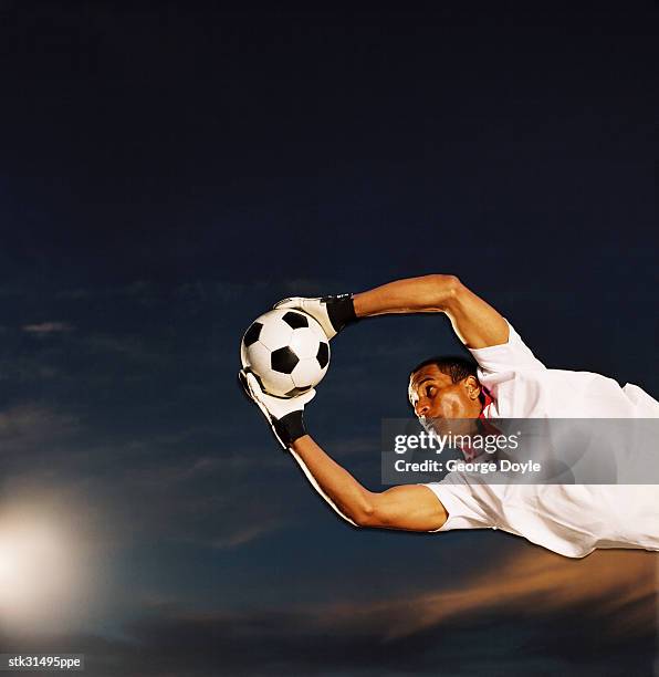 shot of a soccer goalkeeper making a save - making a save stock-fotos und bilder