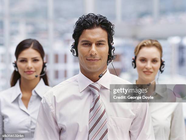 portrait of a businessman and two businesswomen wearing headsets in an office - communication occupation stock pictures, royalty-free photos & images