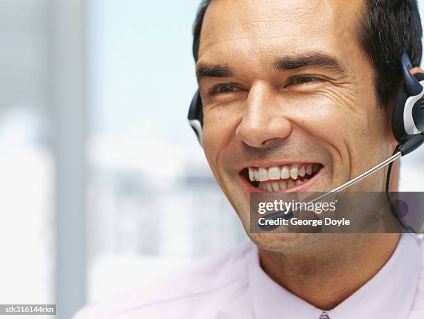 close-up of a businessman wearing a headset in an office - communication occupation stock pictures, royalty-free photos & images