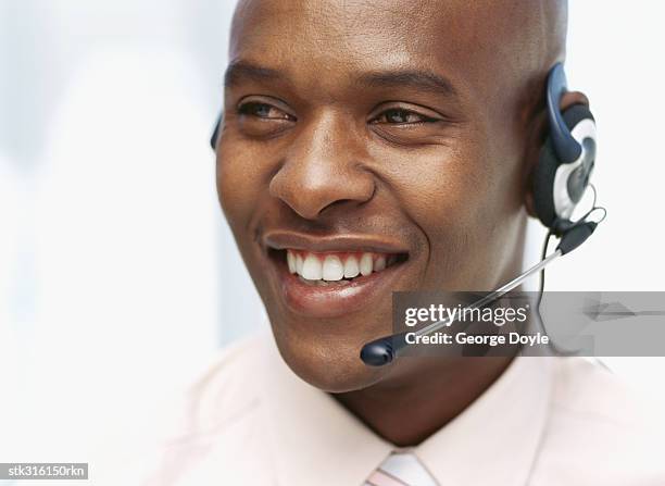 close-up of a businessman wearing a headset in an office - communication occupation stock pictures, royalty-free photos & images